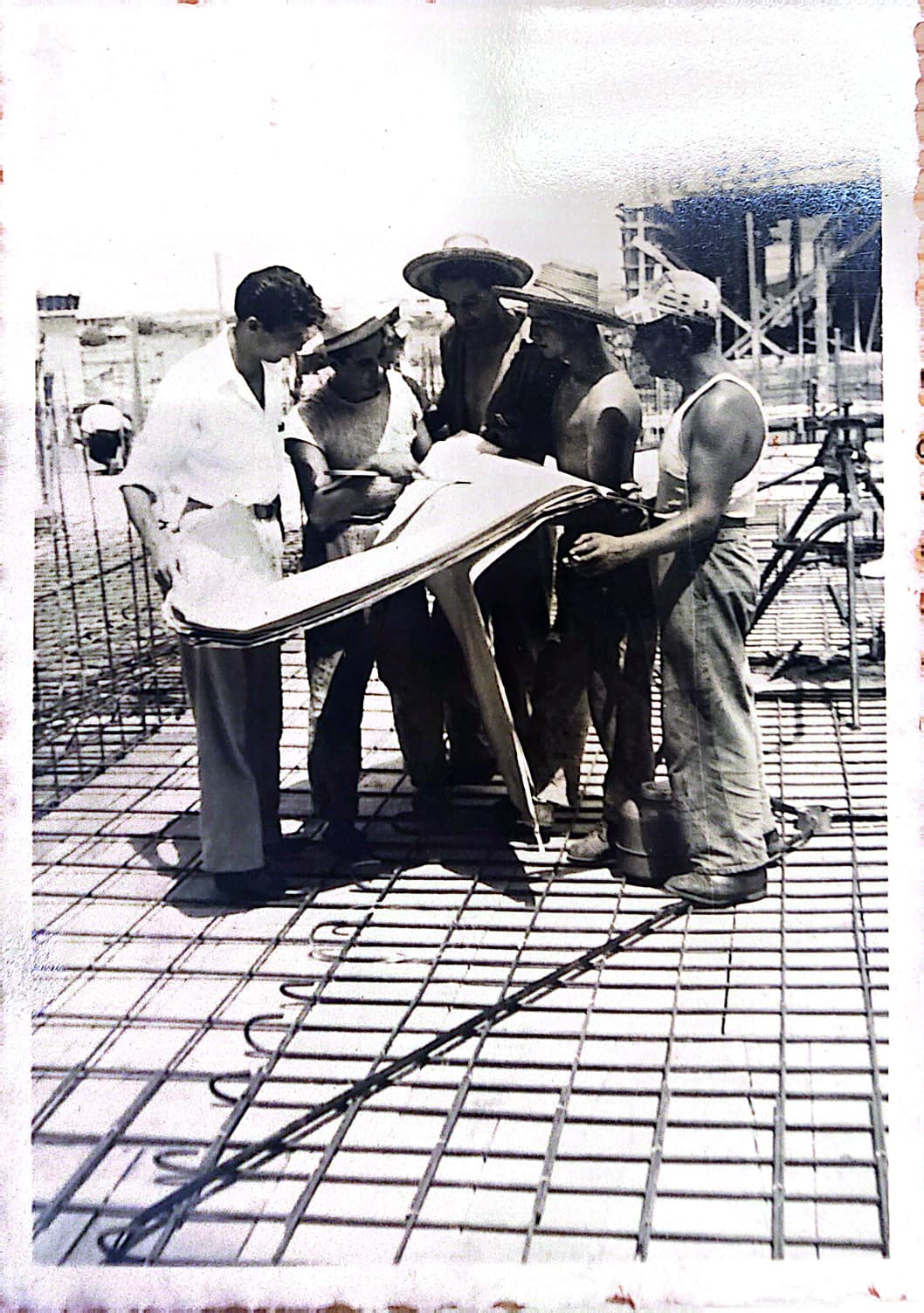 Family archive: builders reviewing plans on a construction site in Maracaibo